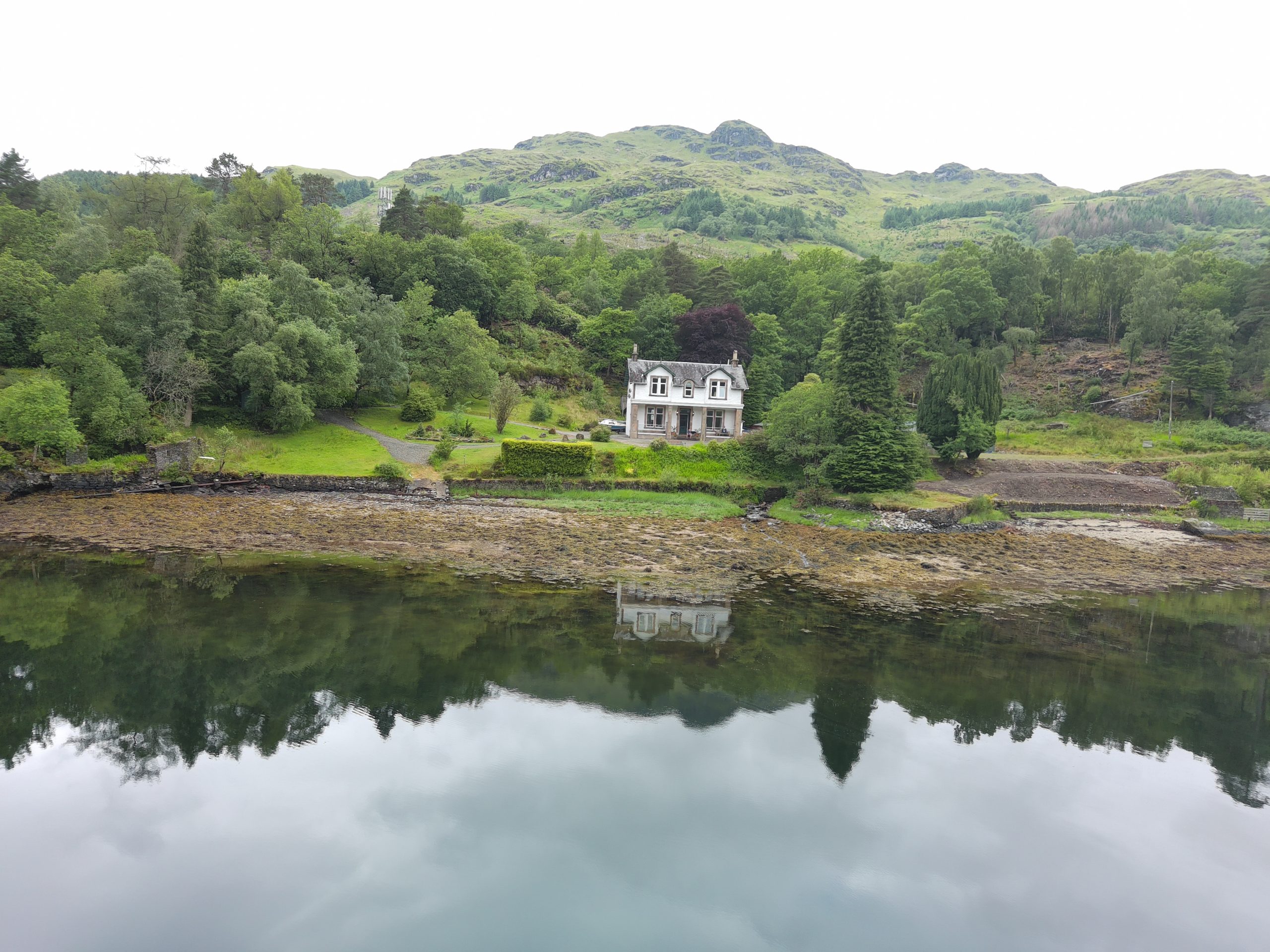A detached retreat venue on the banks of Loch Goil with woodland behind
